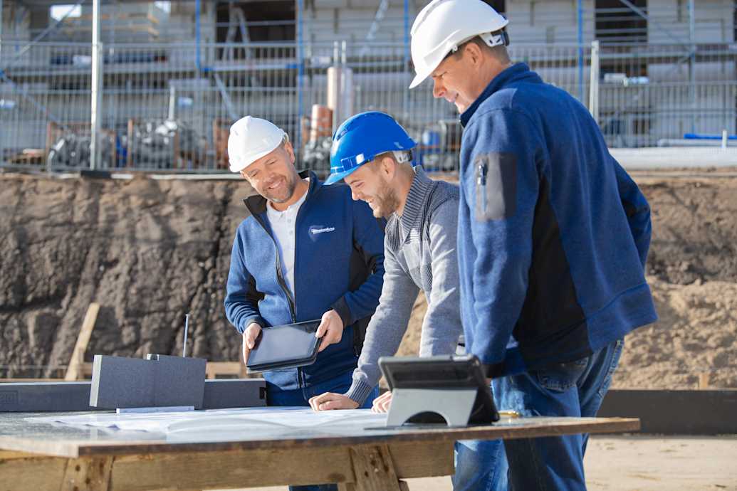 Planung mit Triotherm Meesenburg Mitarbeitende mit Kunden und Triotherm am Tisch auf Baustelle