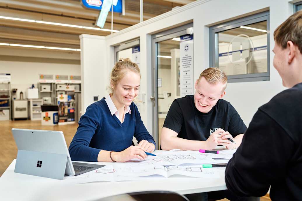 Meesenburg Sicherheit & Service Beratung Meesenburg Mitarbeitende am Tisch mit Kunde und Gebäudeplänen